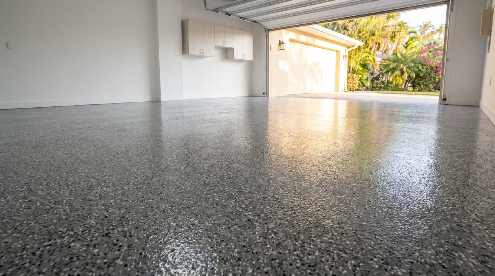 Glossy gray flake epoxy floor in a Tampa two-car garage with the door open